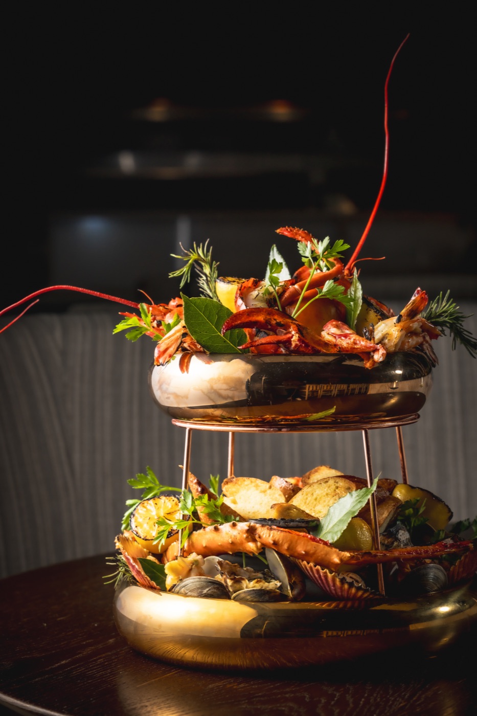 A two-tier seafood plateau with lobster, crab and shellfish on a brass stand