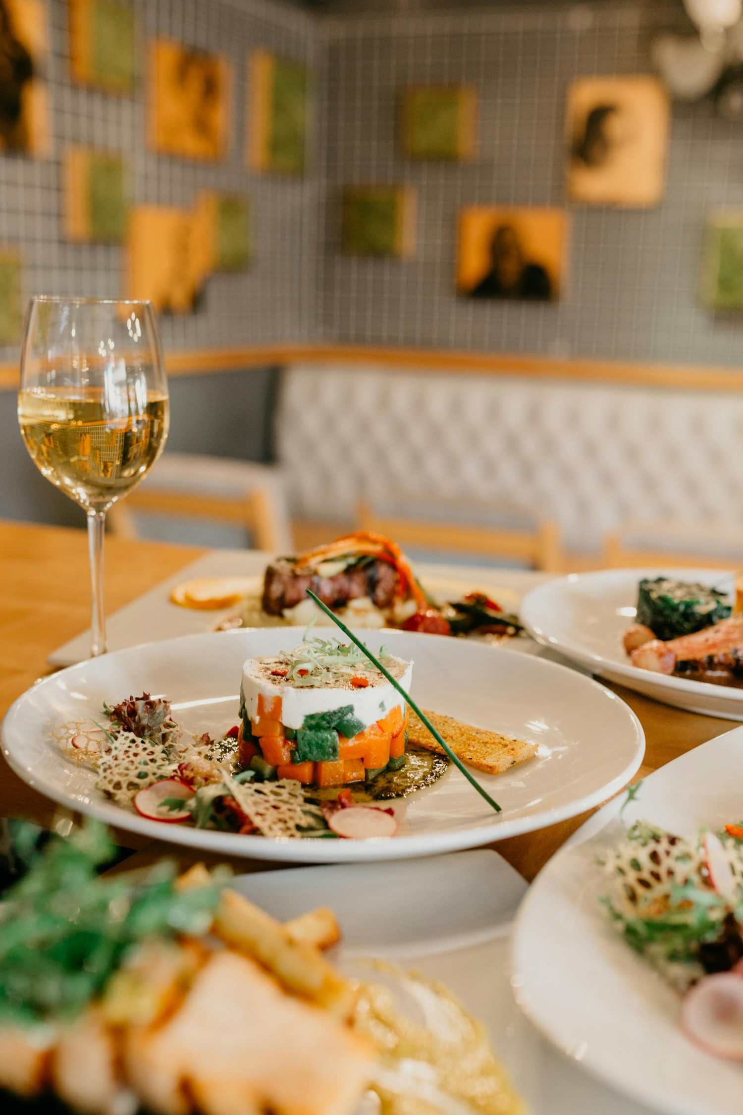 Fine dining plate with a glass of white wine at an Aspen restaurant