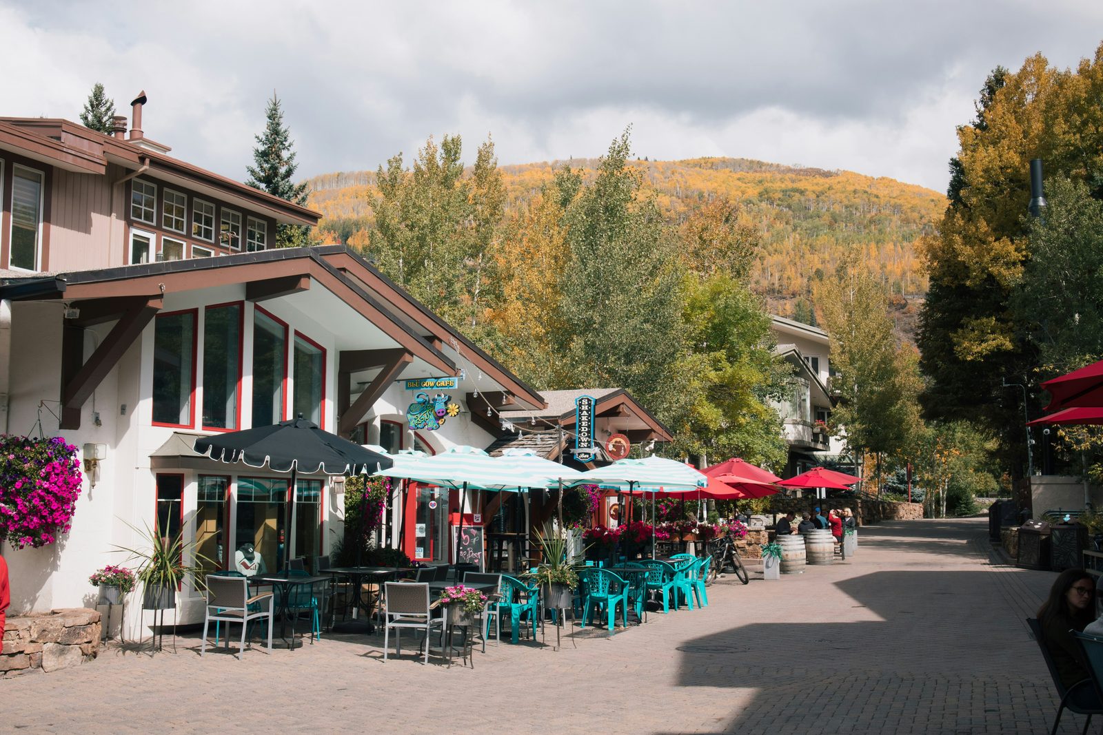 Vail Village, Colorado in early autumn - alpine-style buildings with outdoor dining patios on a cobblestone pedestrian street